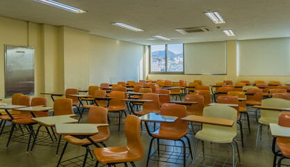 Empty desks and large whiteboard in classroom.