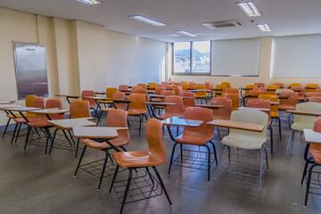 Fototapeta na wymiar Empty desks and large whiteboard in classroom.
