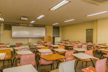 Empty desks and large whiteboard in classroom.