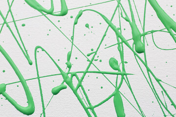 Green paint splashes on white canvas as background. Art and creativity