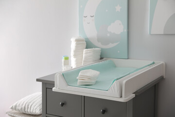 Chest of drawers with changing tray and pad in baby room. Interior design