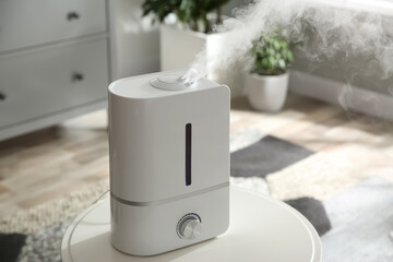 Modern air humidifier on table at home - obrazy, fototapety, plakaty