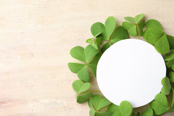 Frame of clover leaves and blank card on light table, flat lay with space for text. St. Patrick's...