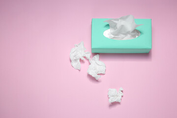 Used paper tissues and box on pink background, flat lay. Space for text