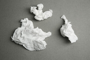 Used paper tissues on grey background, flat lay