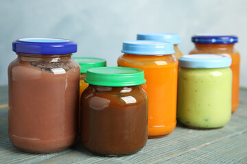 Jars with baby food on wooden table