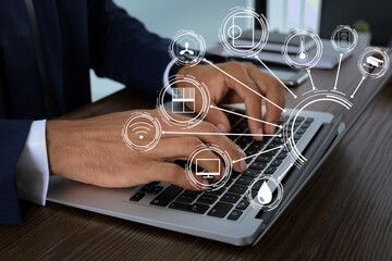 Man using laptop to control smart home, closeup. Automatic systems