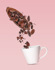 Cocoa pod and beans falling into cup on pink background