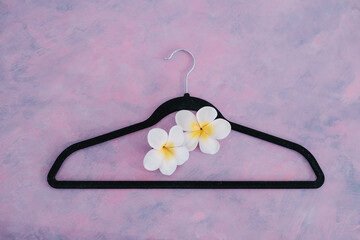 fashion industry concept, velvet clothes hanger on pink desk with flower
