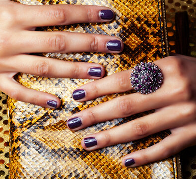 pretty fingers of african american woman holding money closeup with purse, luxury jewellery on python clutch, cash for gifts