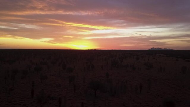 Australian outback golden sunset with the Olgas rocks in the far background
