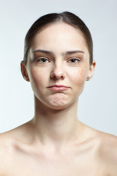 Headshot of emotional female face portrait with offended facial expression.