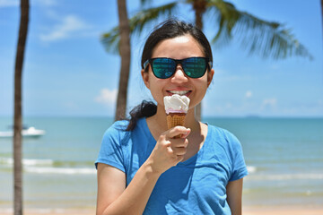 Happy woman enjoying in ice cream on the beach.