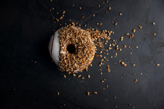 doughnut  covered with nuts and dark background
