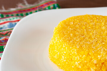 tasteful and colorful brazilian corn couscous on a wooden table