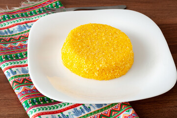 tasteful and colorful brazilian corn couscous on a wooden table