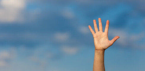 A woman opened palm over a blue sky background