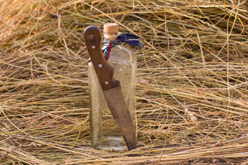 Old bottle and knife. Ancient secret natural solution, drink.