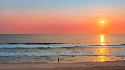 Obraz premium Person standing on beach aerial sunrise ocean view on Gold Coast