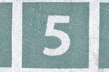 Number 5 on green cement floor.