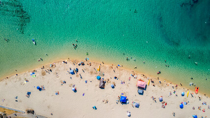 Top down aerial view over Tallebudgera beach with people swimming in the creek