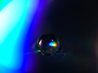 blurred water droplets with blue light on black backgronud, dark and shiny , abstract background, macro image for card design