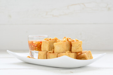 Deep fried tofu is cut into square balls on plate