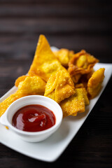 Deep fired Chinese Thai style wonton with minced pork and sweet and sour sauce in ceramic dish.