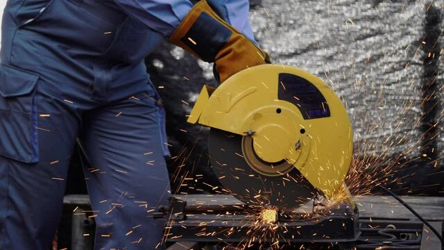 Technician or Construction worker use electric saw to cutting a metal and steel Sparks. Must wear protect clothing, metal masks and gloves to prevent dangerous work accidents. Concept industrial