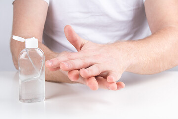 Man person using small portable antibacterial hand sanitizer on hands.