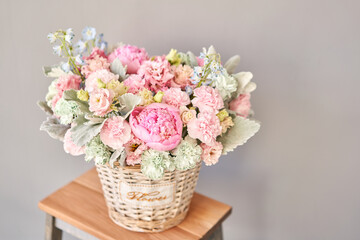 Beautiful flower composition a bouquet in a wicker basket. Floristry concept. Spring colors