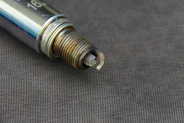 with a candle wrench unscrewed the spark plug which is covered with soot