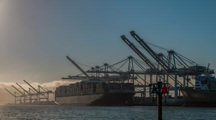 Port of Oakland with cargo ship in port for unloading under the cranes 