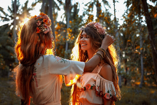 two beautiful young woman in summer dresses outdoors at sunset