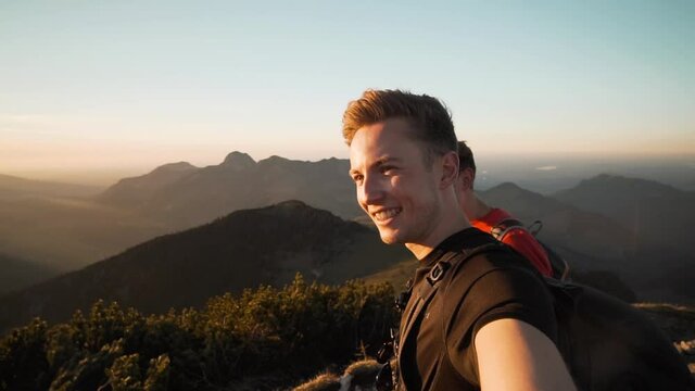 A young caucasian man with his friend smiling at camera while showing the landscape