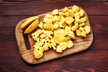 peeled sliced raw potatoes on a wooden board. Preparing vegetables for cooking.