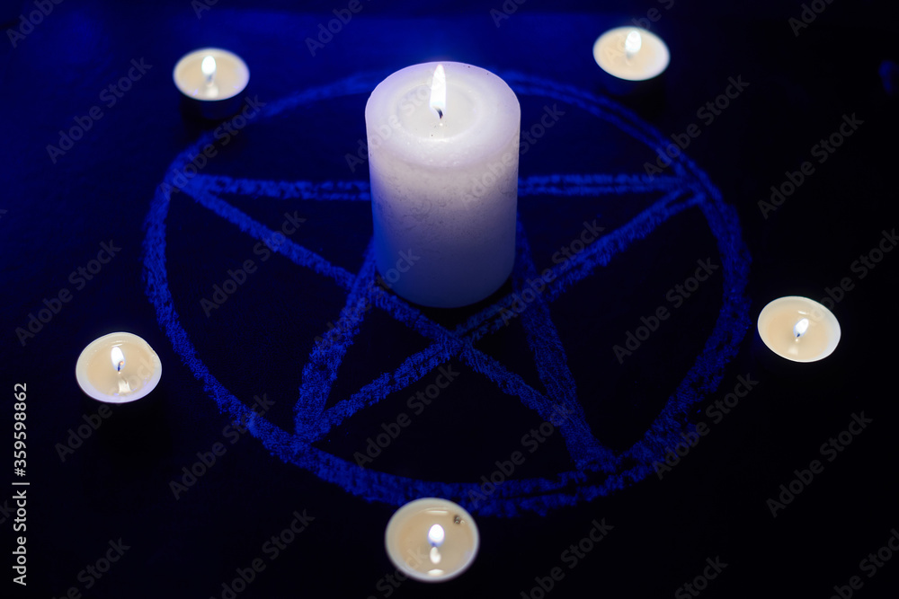 Wall mural pentagram and burning candles. the magical ritual of satanism, invocation of spirits, spiritualistic