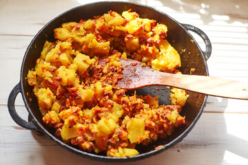 Baked potatoes with minced meat, onions and carrots baked in a pan.