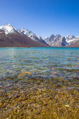 Nianbaoyuze, A sacred lake in Tibet with green water and snow mountains in the back.