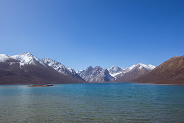 Nianbaoyuze, A sacred lake in Tibet with green water and snow mountains in the back.