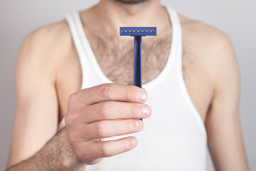 Caucasian man holding disposable razor.
