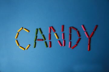 lettering CANDY made of gumdrops isolated on blue background