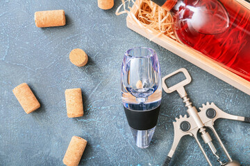 Fototapeta na wymiar Wine aerator with bottle and corkscrew on color background