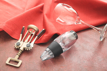 Aerator for wine, glass and corkscrew on color background