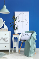 Chest of drawers and armchair with plaids and pillow in modern room