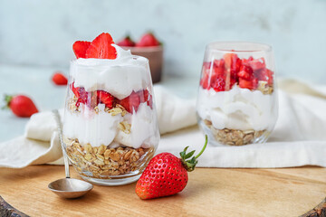 Tasty strawberry dessert in glass on table
