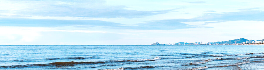 Obraz premium Waves washed ashore with beautiful blue sky and city background, banner picture.