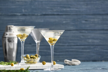 Glasses of tasty martini cocktail with olives on table