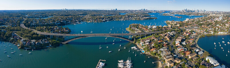 Naklejka na ściany i meble Aerial view of the Gladesville bridge, Parramatta river and the Sydney suburb of drummoyne looking east towards the city.