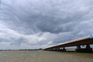 Dark clouds above the Moerdijkbrug over water named Hollands Diep.